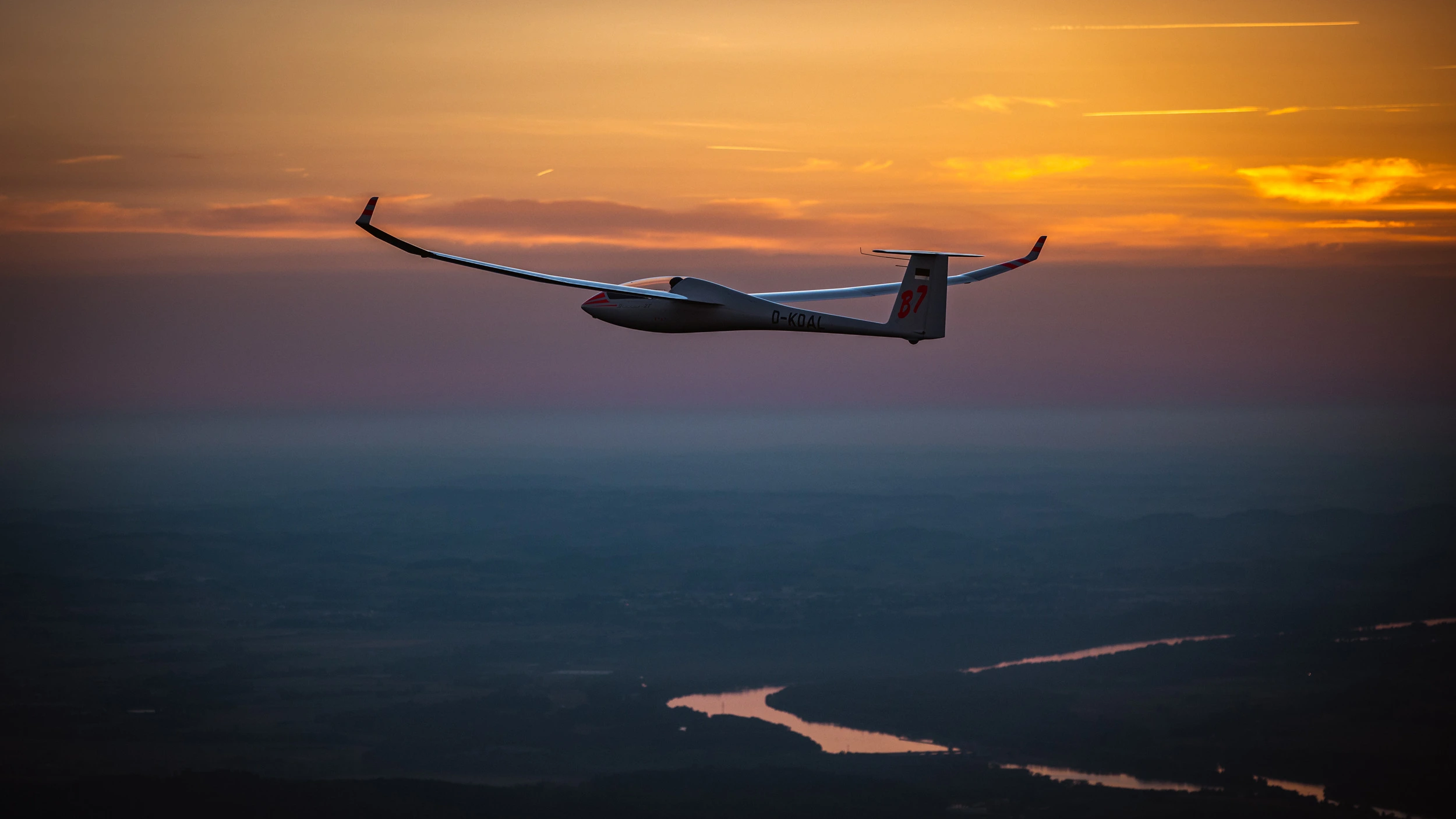 Background image: glider at sunset