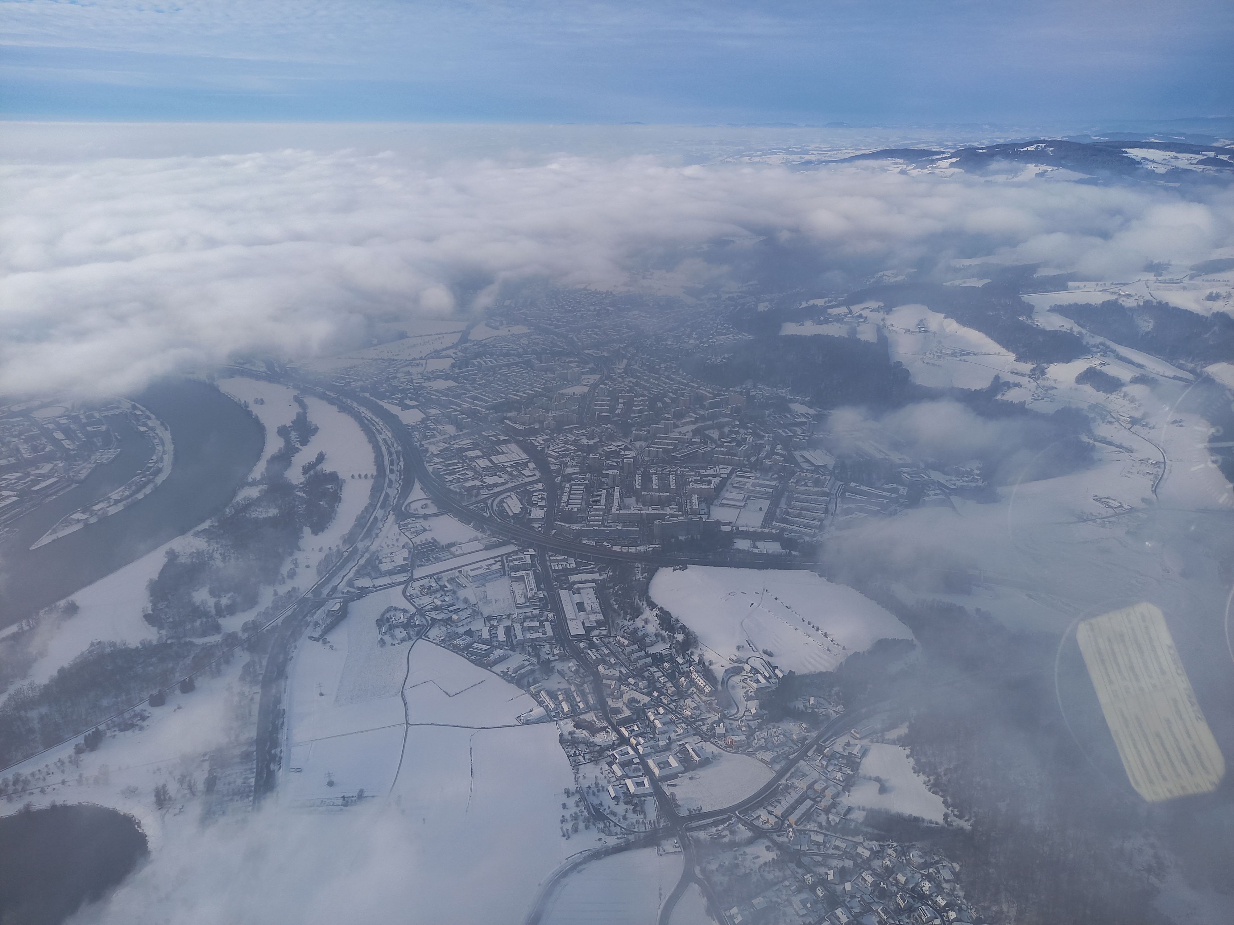 Skifliegen im Winter 2023/24 mit Blick auf das verschneite Urfahr und die Universität Linz.